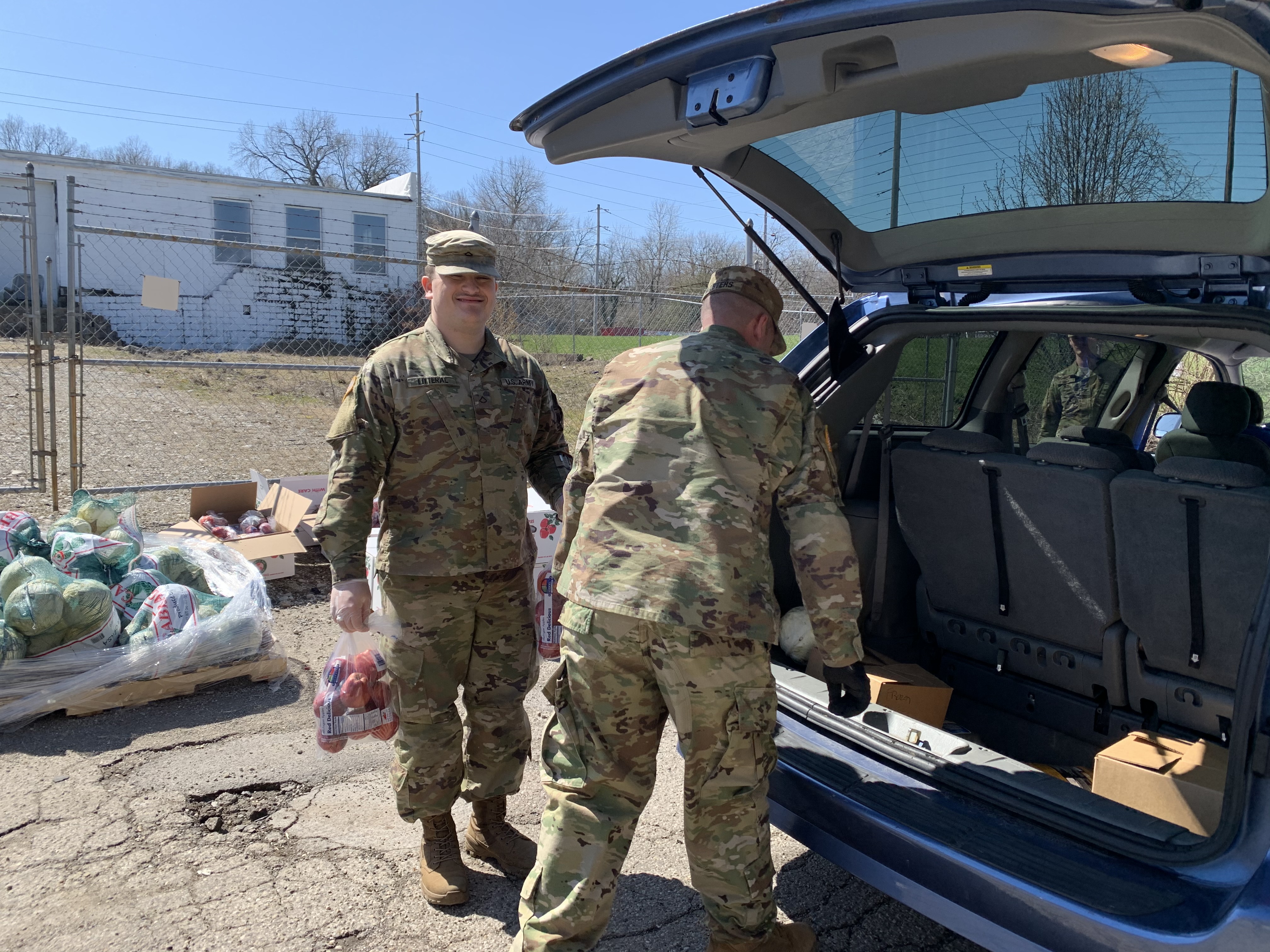 Soldiers load boxes into SUV.